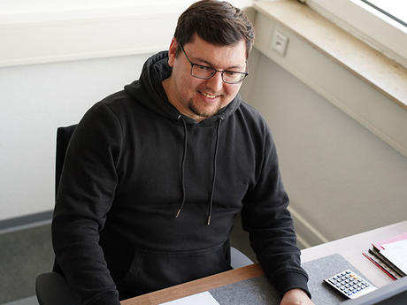 Mann sitzt vor einem Computer und arbeitet im Büro